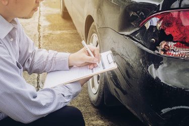 Insurance agent working on car accident claim process Insurance agent working on car accident claim process